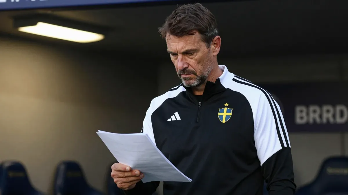 A 35-year-old Swedish football coach with a rugged build, wearing a plain black and white polyester training top, stands...