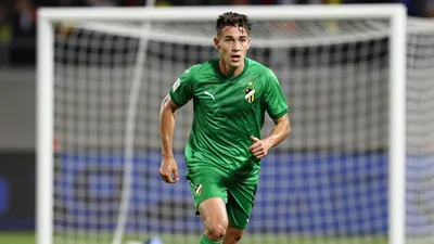 A Häcken player in a green jersey sprinting towards the goal