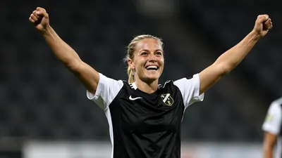 A 30-year-old female Häcken midfielder, with a lean athletic build, celebrates her goal with a triumphant expression...