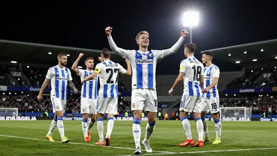 A photo of a Häcken player celebrating a goal with the team's colours, a mix of blue and white, taken at the Guldfågeln...