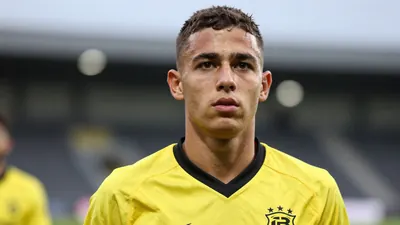 Athletic, 20-year-old midfielder in a solid yellow and black kit, blurred stadium background
